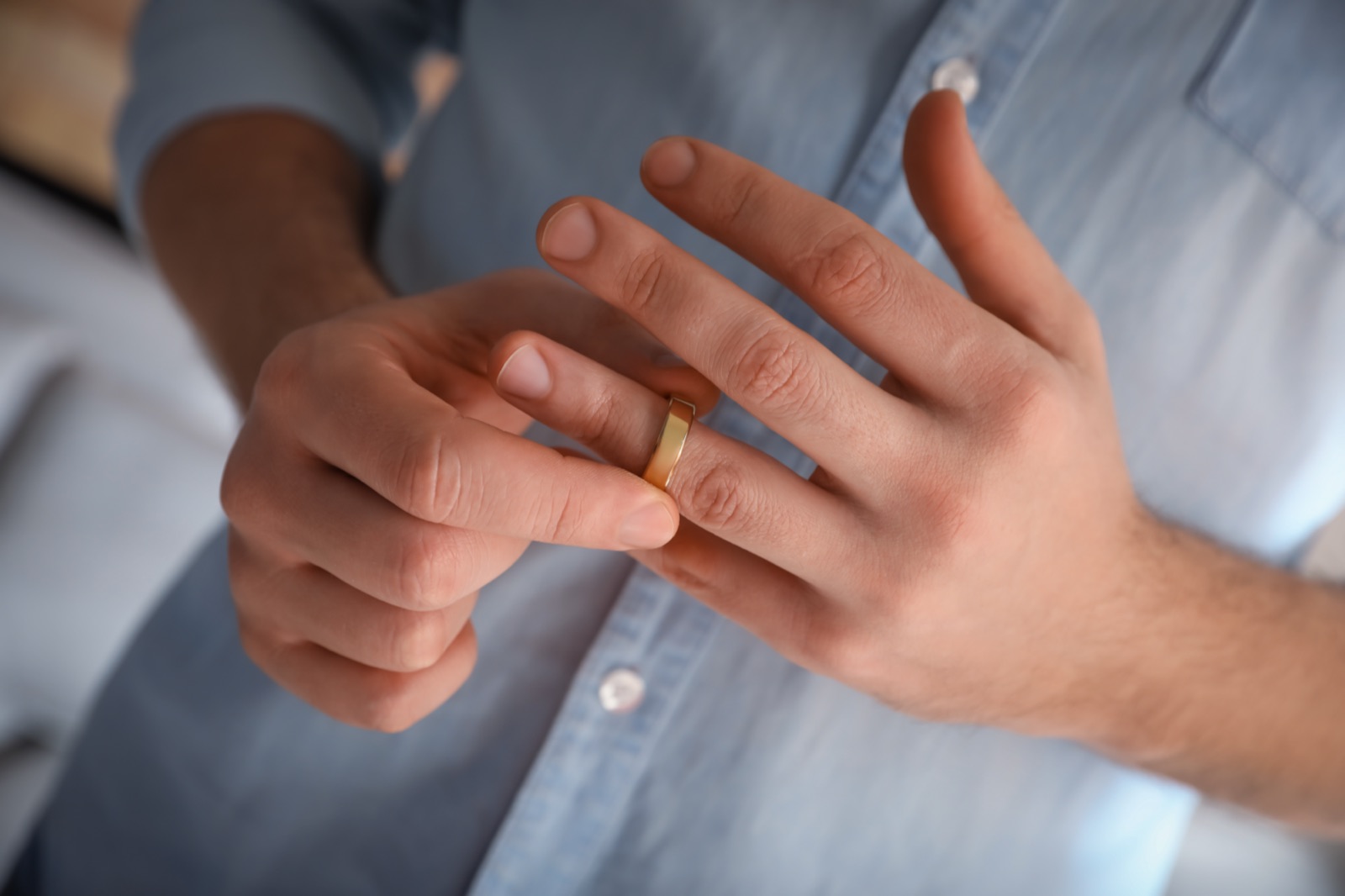 A man slipping off his wedding ring