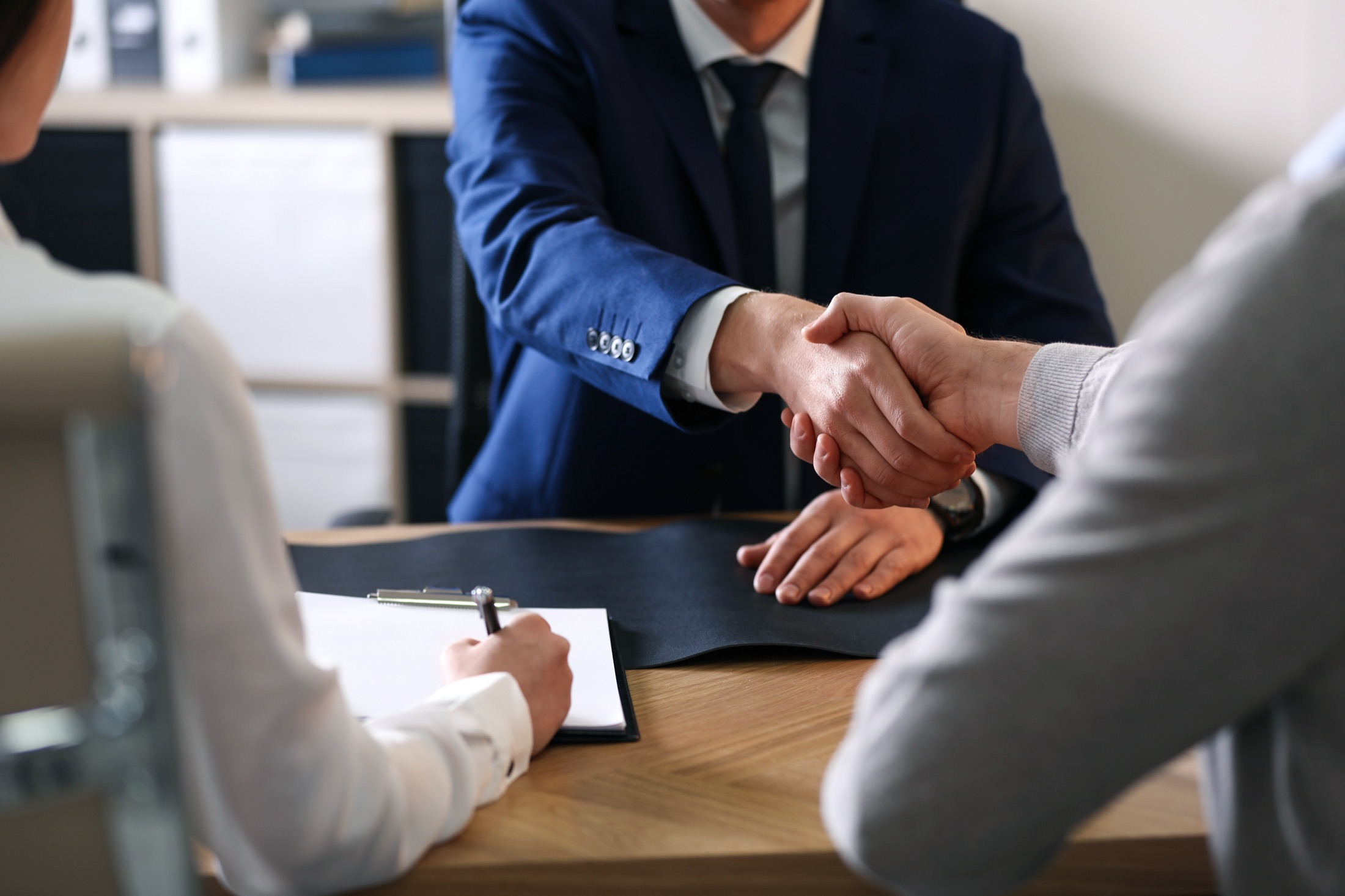 An attorney shaking hands with clients across the desk