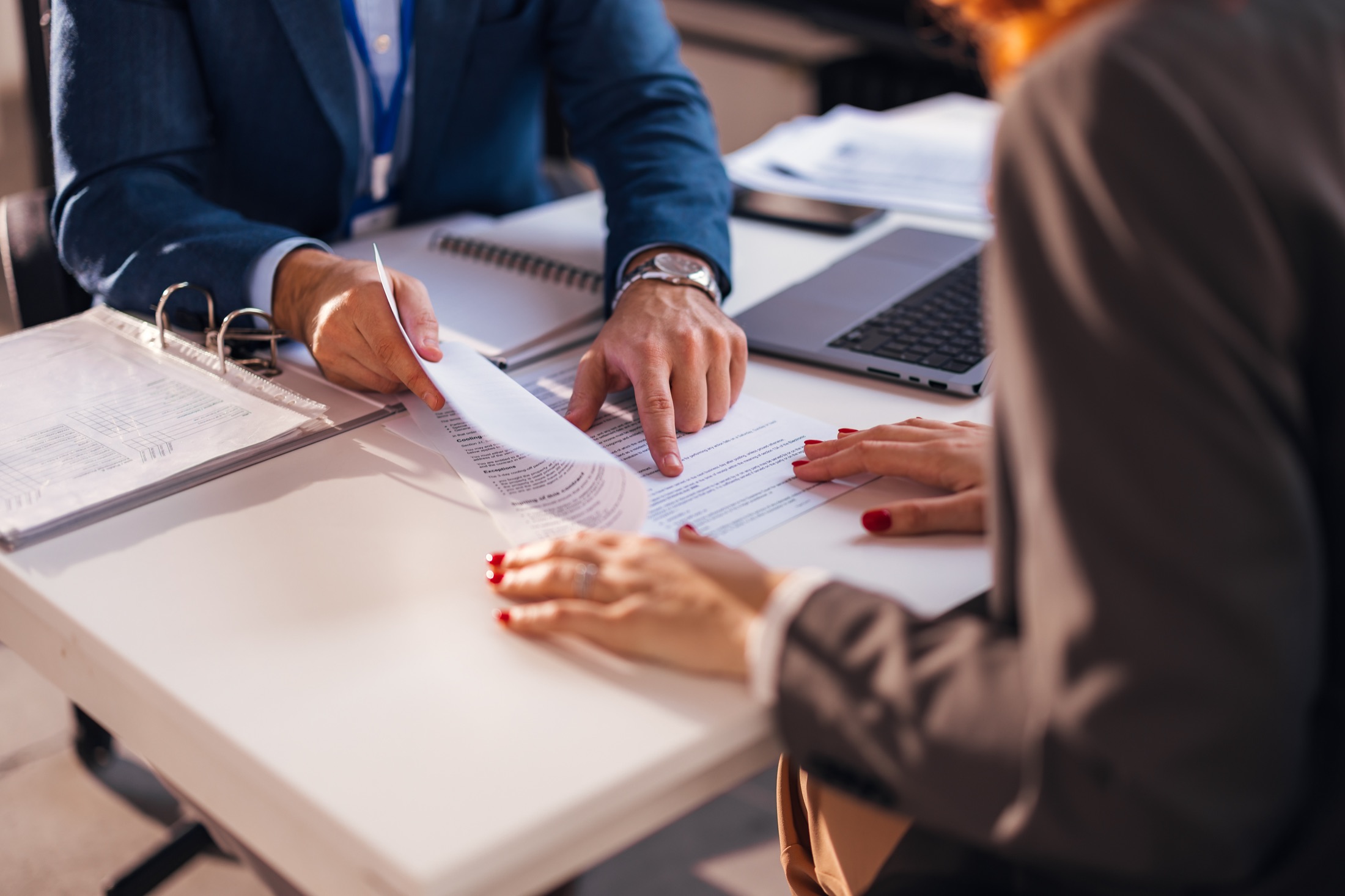 An attorney reviewing documents with a client at the desk