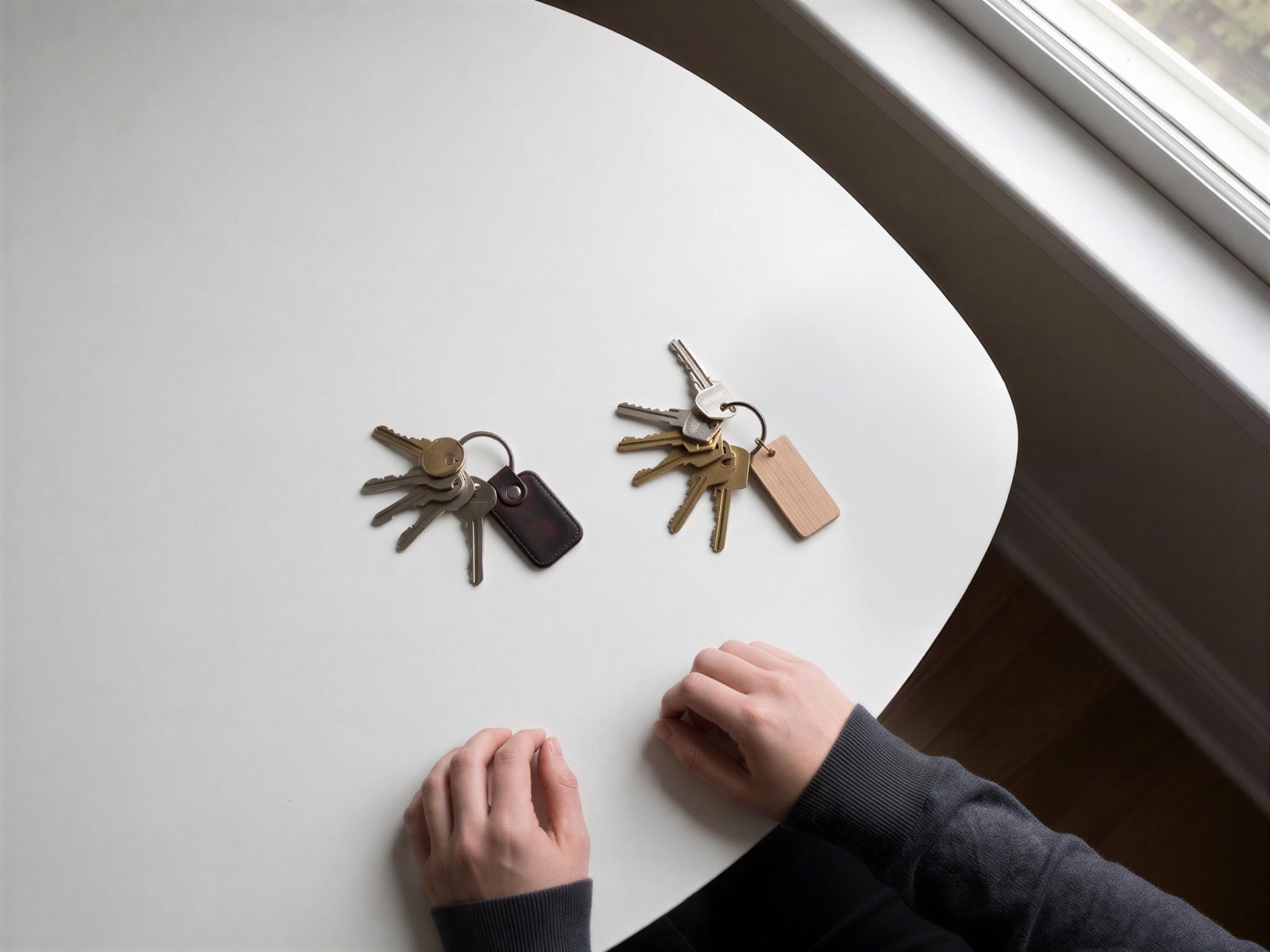 Two sets of house keys resting side by side on a table